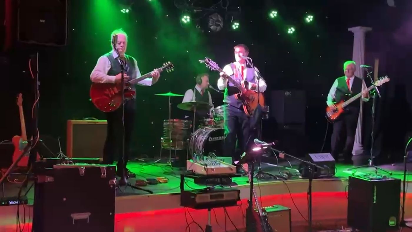 The Originals on a lit club stage with green stage lighting